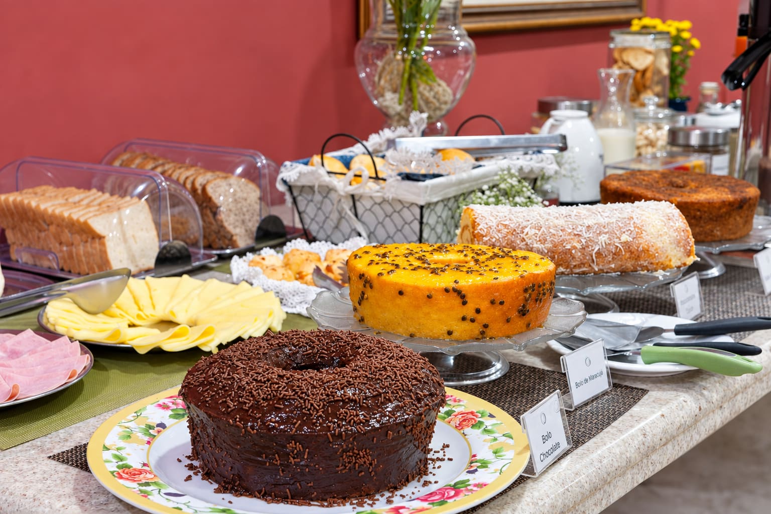 Buffet de café da manhã com bolos caseiros, pães e frios