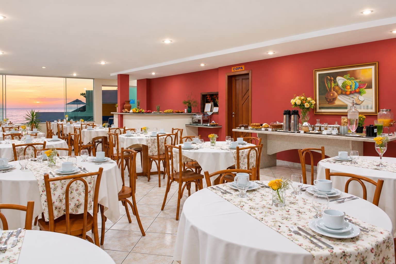 Salão do café da manhã com buffet e vista para o nascer do sol