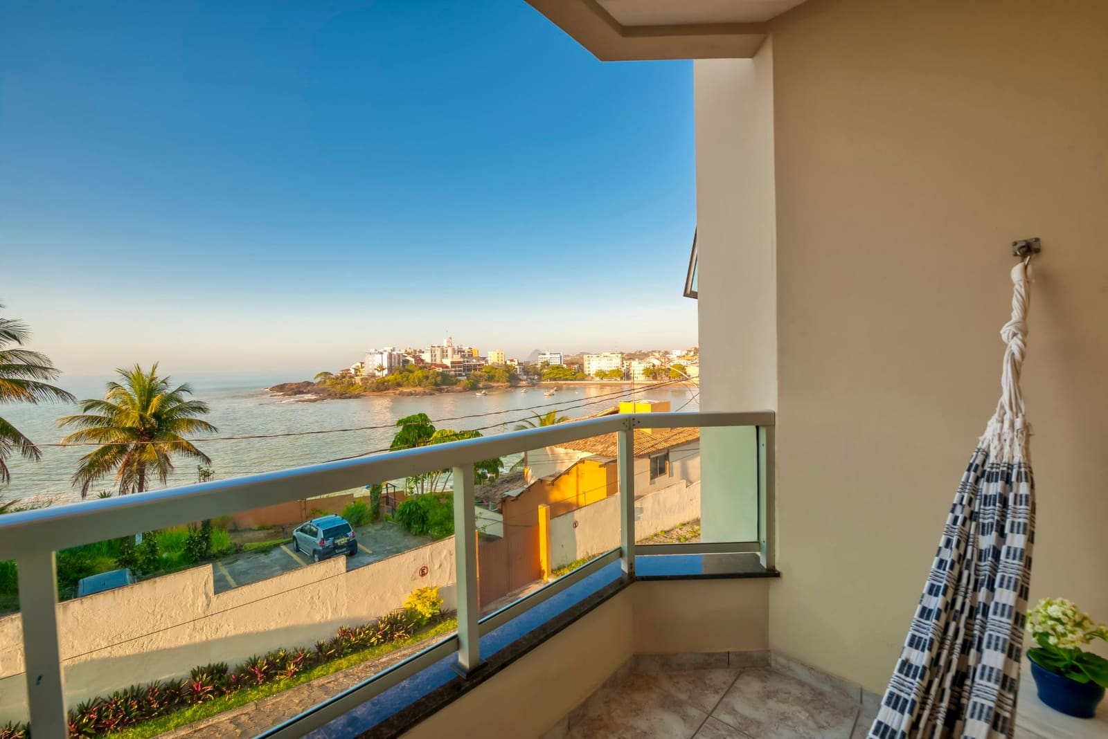 Varanda de quarto com vista para a praia e coqueiros
